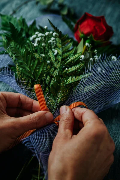 在西班牙加泰罗尼亚 一个男人用加泰罗尼亚国旗装饰的彩带系着一束红玫瑰的特写镜头 庆祝圣乔治日圣若尔达日 传统上是送红玫瑰给加泰罗尼亚 — 图库照片