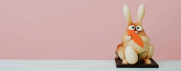 スペイン語で Mona Pascua と呼ばれるチョコレートうさぎですイースターにゴッドチャイルドに与えられた伝統的な菓子ピンクを背景にしたテーブルの上に — ストック写真