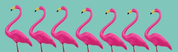 一些假的粉红火烈鸟 站在绿色的蓝色背景上 全景格式 用作网页横幅或标题 — 图库照片