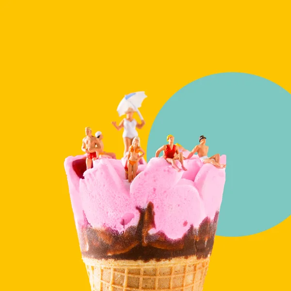 一些穿着泳衣的迷你人在粉红色的预先填好的冰淇淋筒上放松一下 在橘黄色背景上的蓝色圆圈上放松一下 — 图库照片