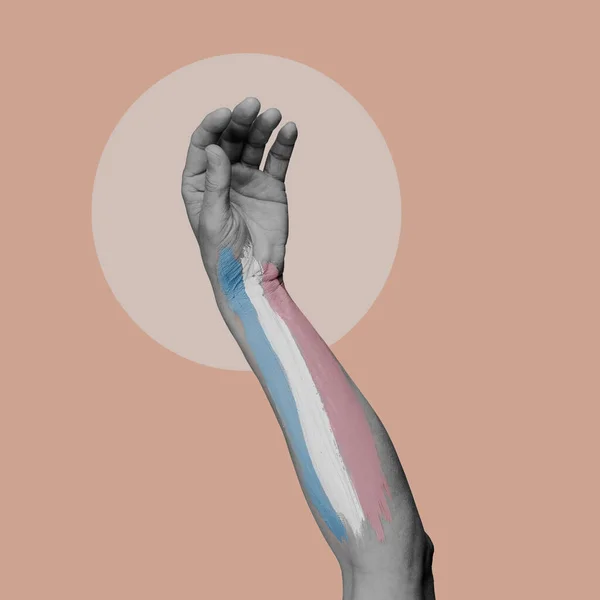 분홍색 배경에 흑백의 사람의 팔에는 트랜스젠더의 자부심 깃발이 그려져 — 스톡 사진