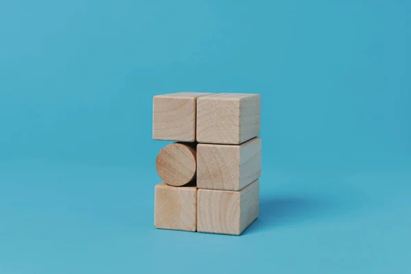 Cylindryczny Blok Stosie Prostokątnych Bloków Niebieskim Tle — Zdjęcie stockowe