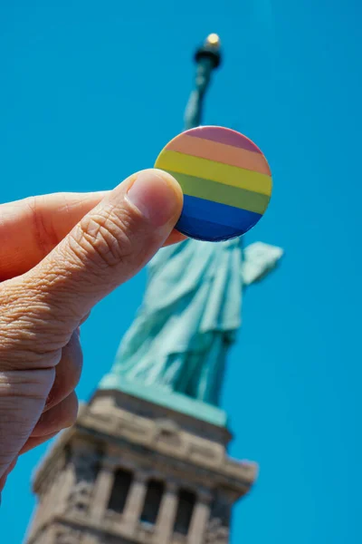 뉴욕주 자유의 여신상 앞에서 프라이드 깃발을 뱃지를 — 스톡 사진