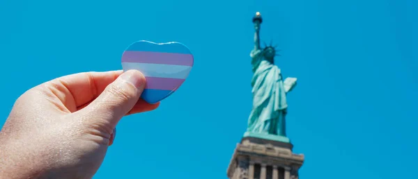 Person Innehar Bricka Mönstrad Med Transgender Stolthet Flagga Framför Frihetsgudinnan — Stockfoto