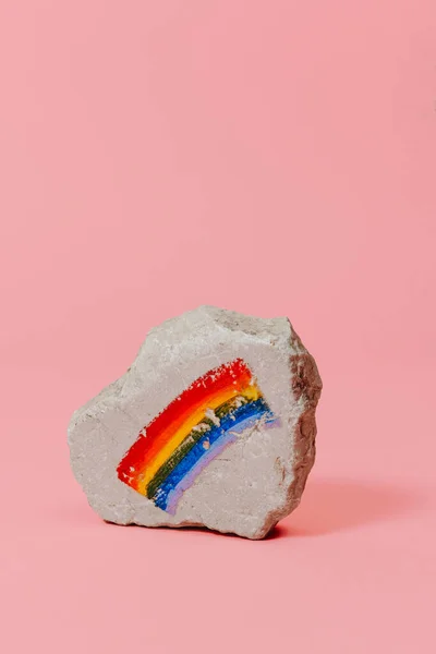 虹の旗が描かれた岩の上にピンクの背景の上に空白のスペースがある — ストック写真