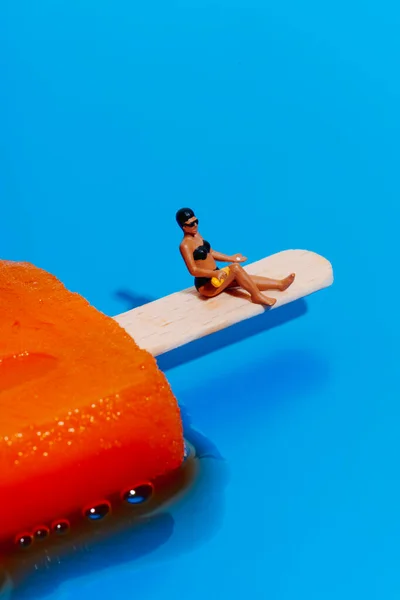 비키니를 미니어처 자신의 다리에 일광욕을 있습니다 배경에 오렌지 양귀비 있습니다 — 스톡 사진