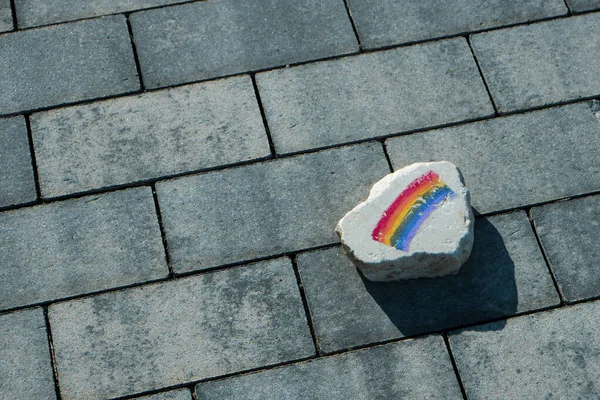 在街道的人行道上 一块有彩虹旗的扁平岩石的特写镜头 — 图库照片