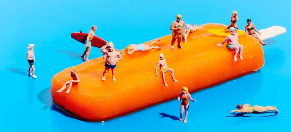 Closeup Some Miniature People Wearing Swimsuit Orange Popsicle Blue Background — Stock Photo, Image