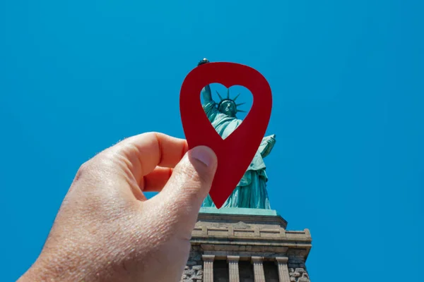 リバティー島以来自由の女神を指している心を持つ赤いマーカーを保持している男の手 ニューヨークで 晴れた春の日に — ストック写真