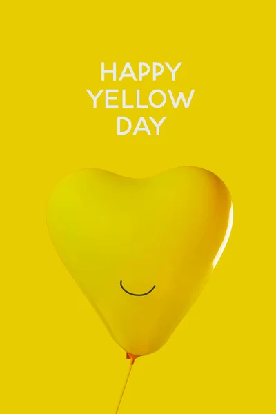 黄色いハート型の風船に笑顔が描かれ黄色の背景に幸せな黄色の日の文字が描かれています — ストック写真