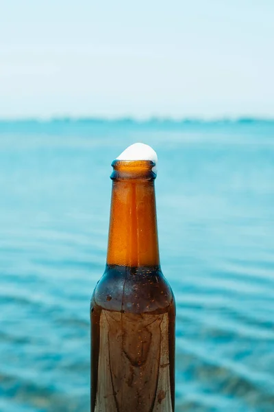 Κοντά Ένα Μπουκάλι Δροσιστικής Μπύρας Λίγο Αφρό Δίπλα Στο Νερό — Φωτογραφία Αρχείου