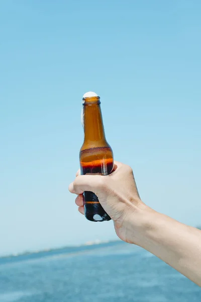 Заткнення Чоловіка Пляшкою Пива Руці Перед Водою — стокове фото