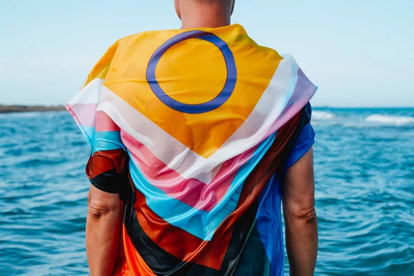海のぬれた人の閉鎖 水の中に立って 性間包括的な進歩の誇りの旗に包まれ 後ろから見られる — ストック写真