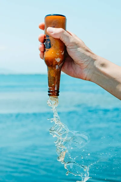 Hombre Sostiene Una Botella Cerveza Abierta Revés Frente Agua Día —  Fotos de Stock