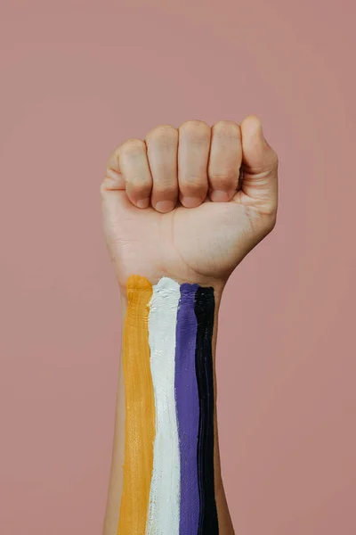 一个年轻的高加索人紧紧抓住的拳头的特写镜头 他们的拳头上涂着粉红的非二元骄傲旗 — 图库照片