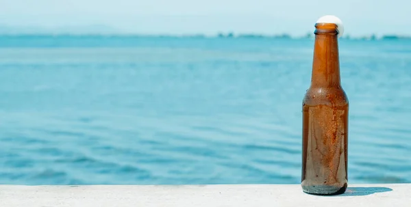 Bir Şişe Ferahlatıcı Bira Iskelede Suyun Yanında Panoramik Bir Formatta — Stok fotoğraf