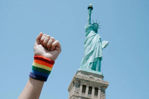 Man Raises His Fist Wearing Wristband Patterned Rainbow Flag Front — Stock Photo, Image