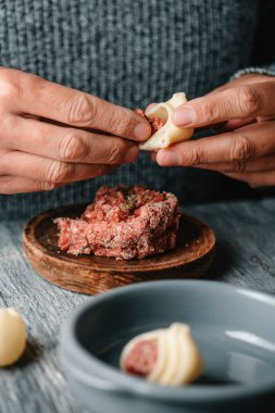 Bir adam Katalan galetini kıyma ile dolduruyor, escudella de Nadal hazırlamak için, İspanya 'nın Katalonya şehrinde Noel' de yenen bir çorba.