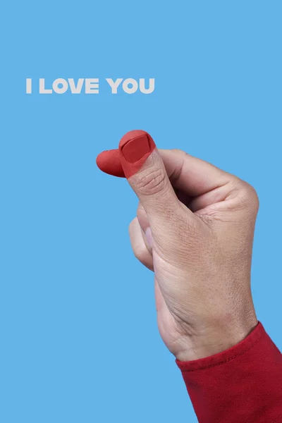 the text I love you and a man, wearing a red shirt, doing the finger heart gesture, with the tips of his fingers painted red, on a blue background
