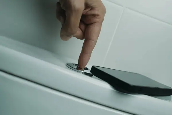 Closeup Man Pressing Button Flush Toilet Using Using His Smartphone — Stock Photo, Image