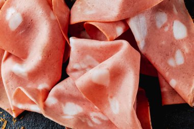 Siyah desenli bir yüzey üzerinde bazı mortadella dilimlerine yakın çekim