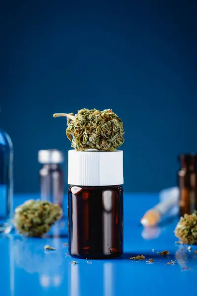 Botão Cannabis Cima Frasco Colocado Numa Mesa Azul Lado Alguns Fotos De Bancos De Imagens