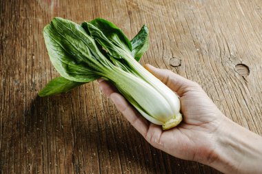 Elinde bok çuvalı olan bir adamın kırsal bir ahşap masada yakın çekimi.