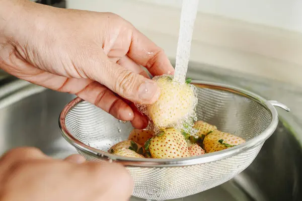 Man Rinses Some Pineberries Colander Running Water Kitchen Tap Royalty Free Stock Images
