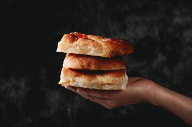 Elinde Katalanca Coca de Sant Joan olan bir adamın eli, tipik katalonya, İspanya ve gelenekselliğin simgesi, karanlık bir arka planda Aziz John arifesinde yenmiş.