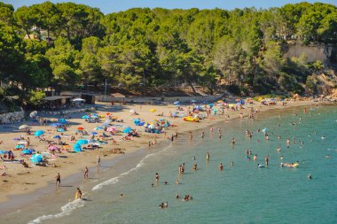 La Ampolla, İspanya - 23 Temmuz 2024: La Ampolla, İspanya 'nın popüler Costa Daurada kıyısındaki Cap Roig plajında tatilciler