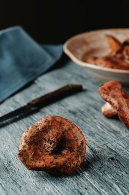 Bazı ham rovellonlar, tipik sonbahar mantarları Katalonya, İspanya 'da, kırsal gri ahşap bir masa üzerinde çok takdir edilir.