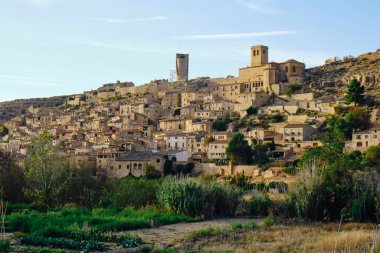İspanya 'nın Katalonya kentindeki resim gibi bir köy, bir dağın kenarına inşa edilmiş, merkezdeki bir kalenin dairesel kulesini aydınlatıyor.