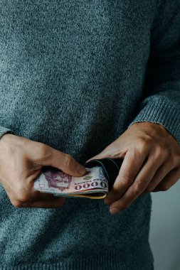 Bir adam cüzdanına Macar forint banknotları koyar ya da çıkartır.