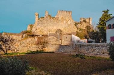 a view of the ruins of Querol Castle, in Querol, Catalonia, Spain, built on top of a hill, at the top of the village, on a winter day clipart