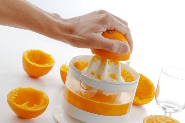 Taze portakal suyu hazırlamak için portakal sıkan bir adamın yakın çekimi.