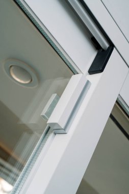 Bir hırsız alarm sisteminin parçası olarak, kablosuz cam kırma dedektörü ve kontak kırıcı ile donatılmış bir pencerenin yakın plan görüntüsü