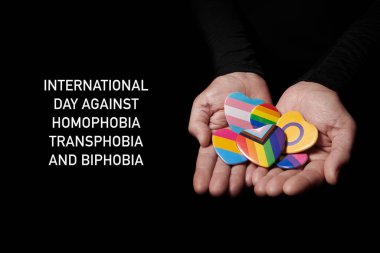 Homofobi, transfobi ve bifobiye karşı uluslararası metin günü ve gökkuşağı bayrağı, transseksüel bayrağı ya da biseksüel bayrak gibi farklı bayraklı rozetler taşıyan bir kişi.
