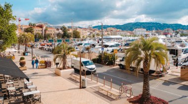 Cannes, Fransa - 9 Mayıs 2025: Cannes Eski Limanı 'ndaki Quai Saint-Pierre manzarası, rıhtım boyunca demirlemiş çok sayıda yatla, ve solda Belediye Binası, Hotel de Ville manzarası