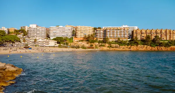 Salou, İspanya - 11 Mayıs 2025: İspanya 'nın Salou kentindeki Capellan Sahili' nin panoramik manzarası, insanların güneşli bir bahar günündeki güzel havanın tadını çıkardıkları deniz manzarası