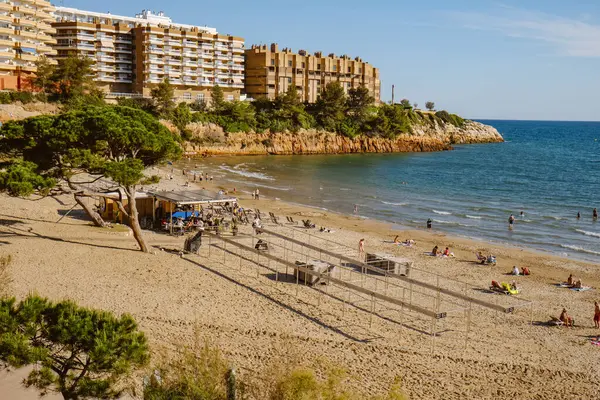 Salou, İspanya - 11 Mayıs 2025: Bazı insanlar güneşli bir pazar günü İspanya 'nın Salou kentindeki Capellans Plajı' nda hoş havanın tadını çıkarıyorlar