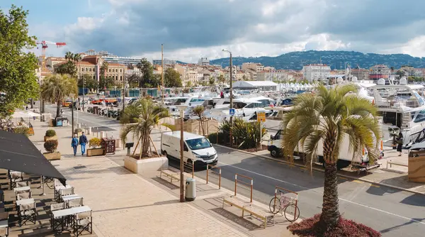 Cannes, Fransa - 9 Mayıs 2025: Cannes Eski Limanı 'ndaki Quai Saint-Pierre manzarası, rıhtım boyunca demirlemiş çok sayıda yatla, ve solda Belediye Binası, Hotel de Ville manzarası