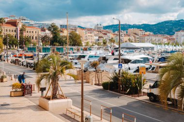 Cannes, Fransa - 9 Mayıs 2025: Eski Cannes Limanı 'ndaki Quai Saint-Pierre, demirlemiş yatları, soldaki belediye binası ve sağda görülen film festivalinin beyaz çadırları