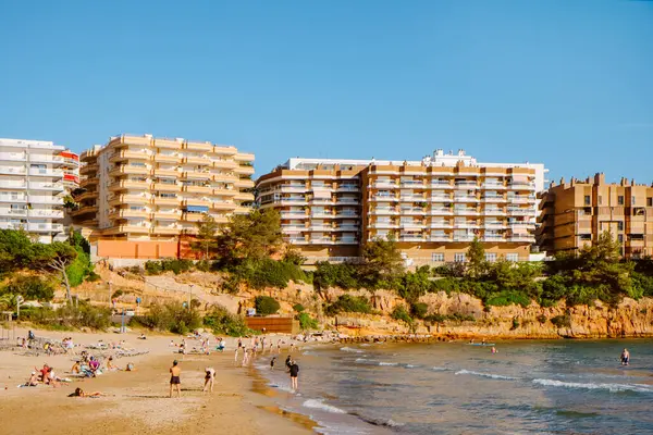 Salou, İspanya - 11 Mayıs 2025: Capellans Sahili manzarası, Salou 'da kayalıklarla çevrili derin bir koy, güneşli bir bahar gününde insanların keyifli havanın tadını çıkardıkları bir yer