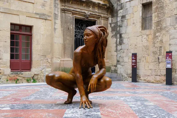 Narbonne, Fransa - 6 Mayıs 2025: Narbonne 'daki Başpiskoposlar Sarayı' nın kamu avlusuna bakan, iki metreden uzun çıplak çömelmiş bir kadını resmeden heykel
