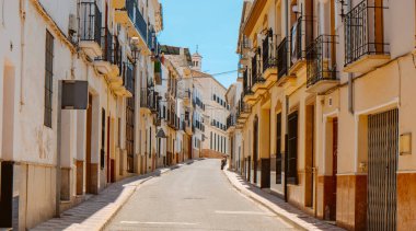 İspanya 'nın Endülüs bölgesinde güneşli bir bahar gününde, Archidona' da sessiz ve boş bir caddenin manzarası.