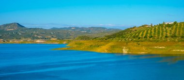 İznajar rezervuarının güney İspanya 'nın Cordoba ilindeki Genil Nehri üzerindeki güneşli bir bahar gününde panoramik bir görüntüsü.