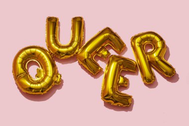 Birkaç altın harfli folyo balonu pembe arka planda 