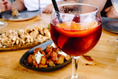 Bir bardak turunçgil dilimli sangria, patatas bravas ve chipirones arka planda bir la andaluza, açık bir yaz günü kapalı bir masa etrafında paylaştı