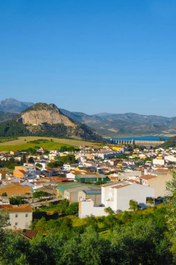 Cuevas de San Marcos 'un çatıları, İspanya' nın Cordoba eyaletine uzanan dağlar ve zeytin ağaçlarıyla kaplı dik tepeye ve Iznajar barajına doğru yol göstermektedir.