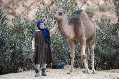 DADES GORGES, MoroCCO - 4 HAZİRAN 2024: Dades vadisindeki develi çocuk, Fas